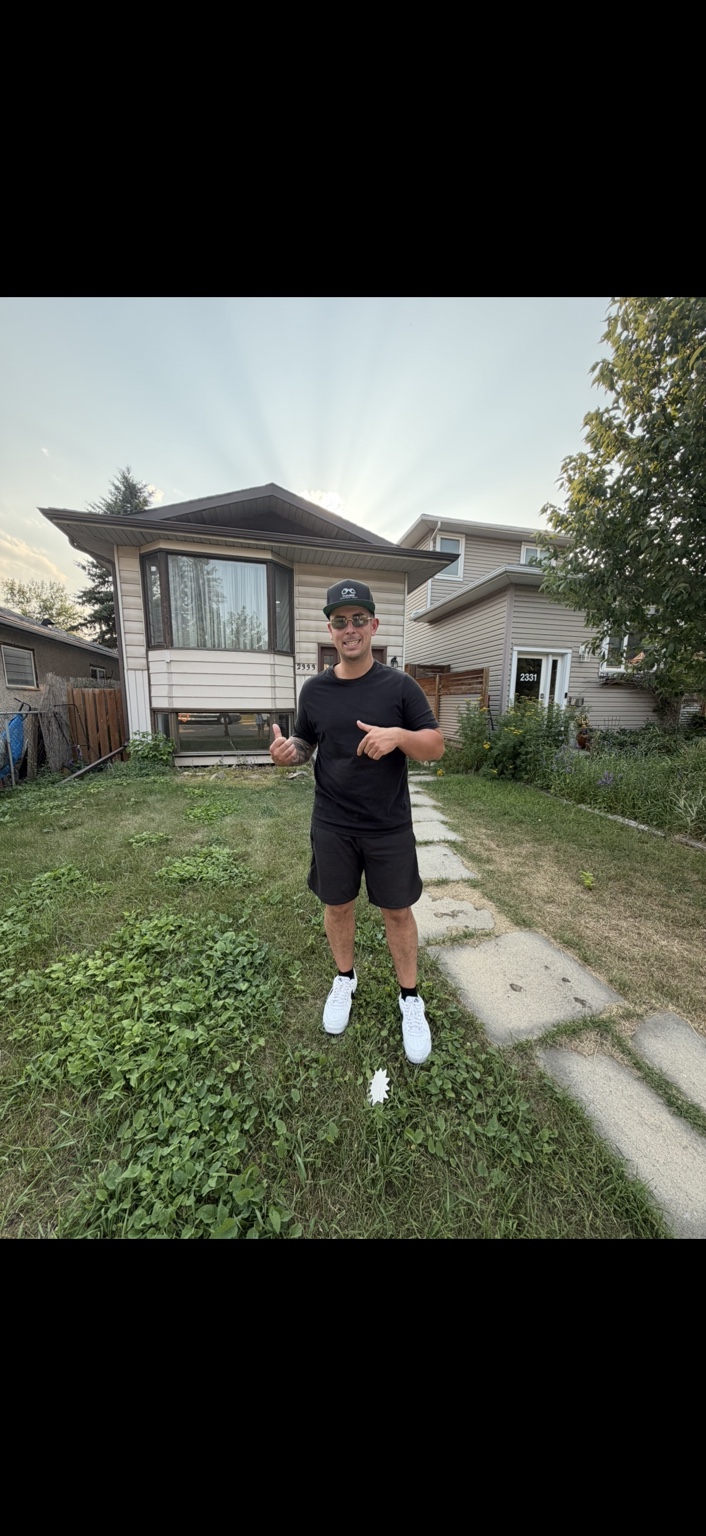 Brandon standing in front of a split-level house