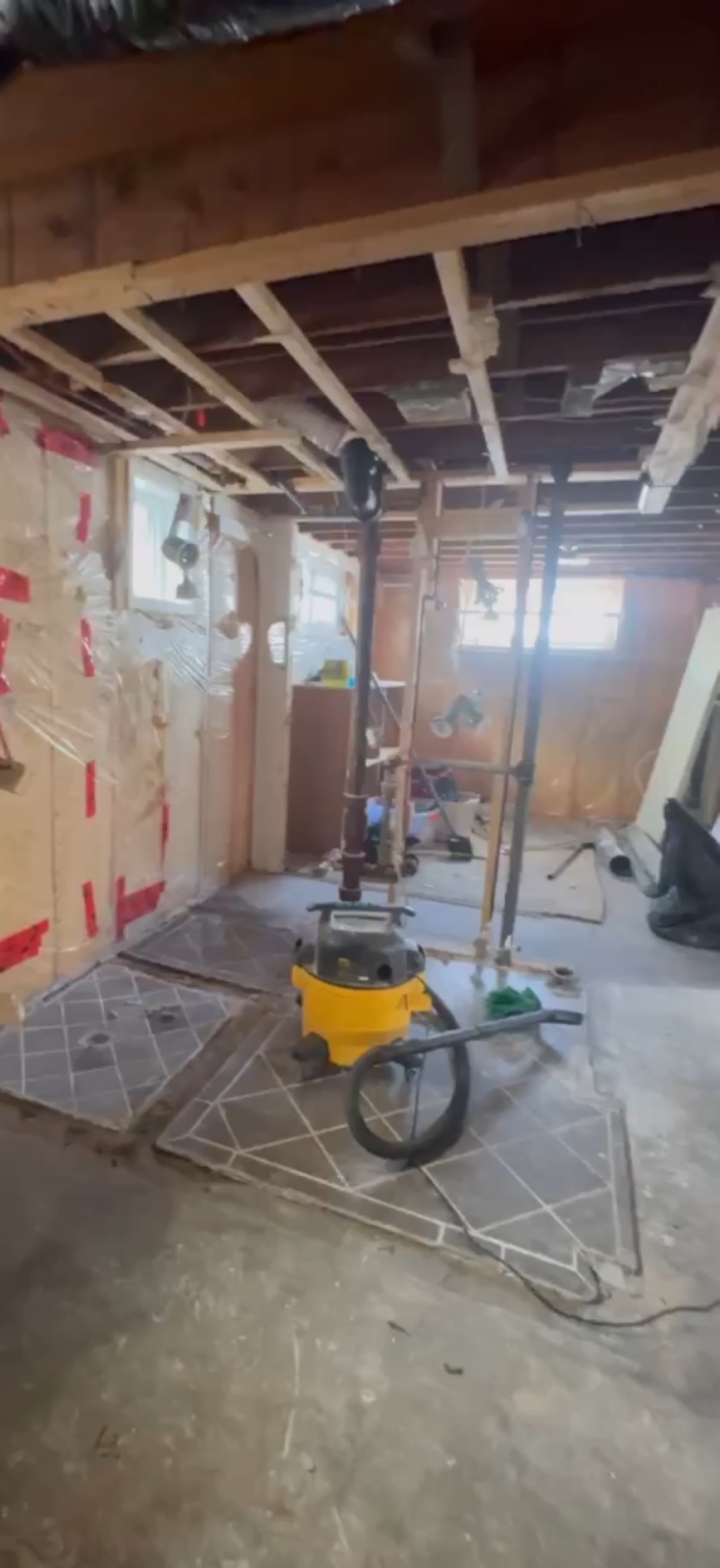 Basement renovation with exposed framing and unfinished surfaces