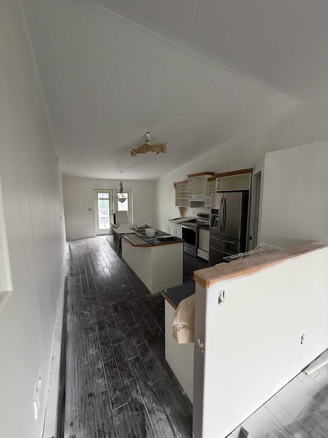 Red Deer kitchen during renovation, with dark flooring and cabinetry being worked on